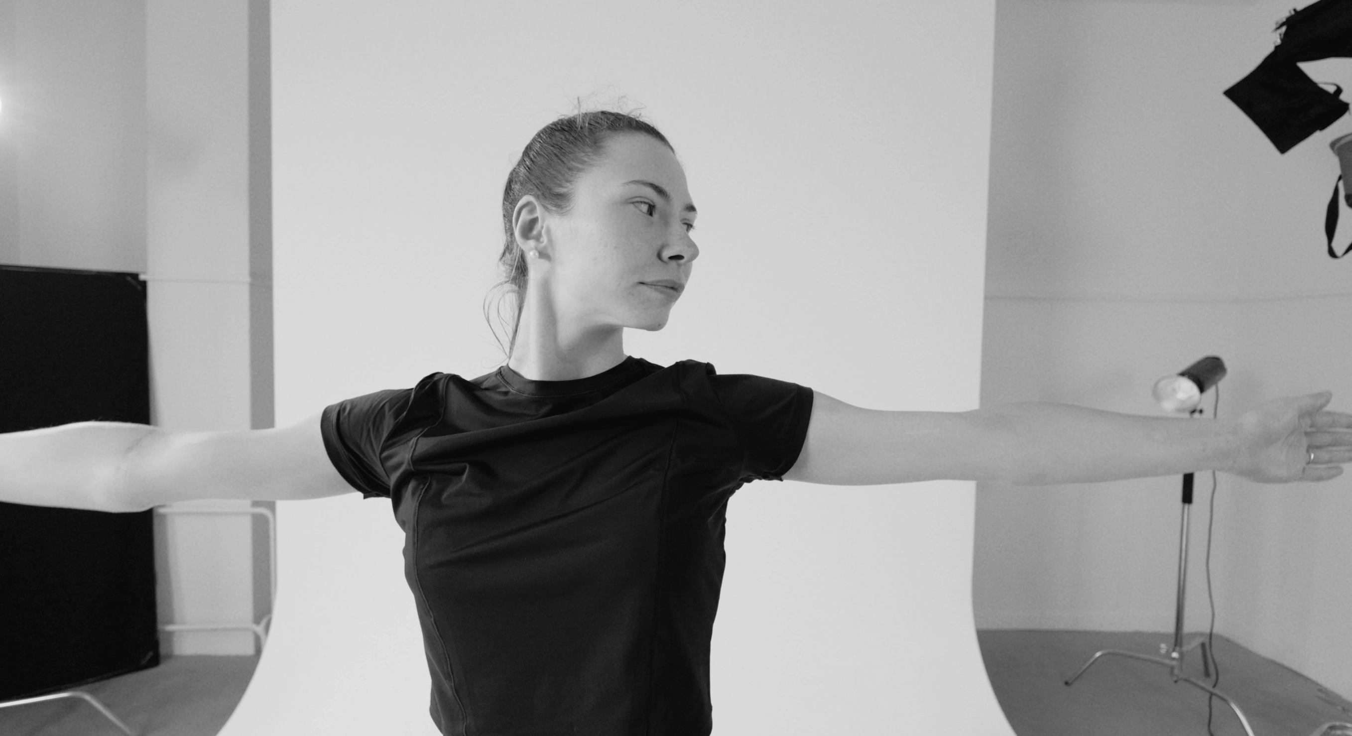 Žena při pomalém vědomém pohybu ve světlém studiu